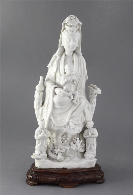 A Chinese Dehua blanc de chine group of Guanyin with child and attendants, 17th/18th century 36cm, height 40cm including wood stand